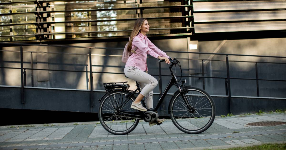 Een vrouw fietst op haar e-bike door de stad