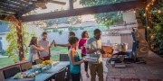 vrienden eten samen onder overkapping in de tuin