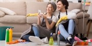 gelukkig stel kijkt tijdens het schoonmaken op de telefoon
