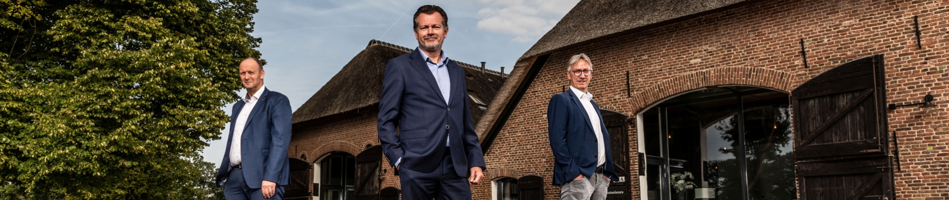 De 3 mannen van Wilbrink staand voor een boerderij